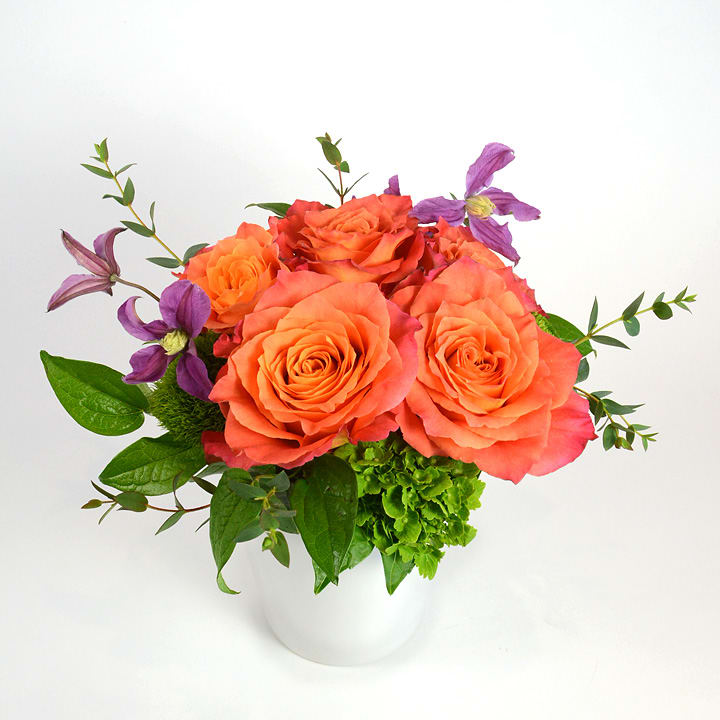 Orange Blossom Orange Blossom - Freespirit roses, hydrangea and clematis together in our white ceramic vase.