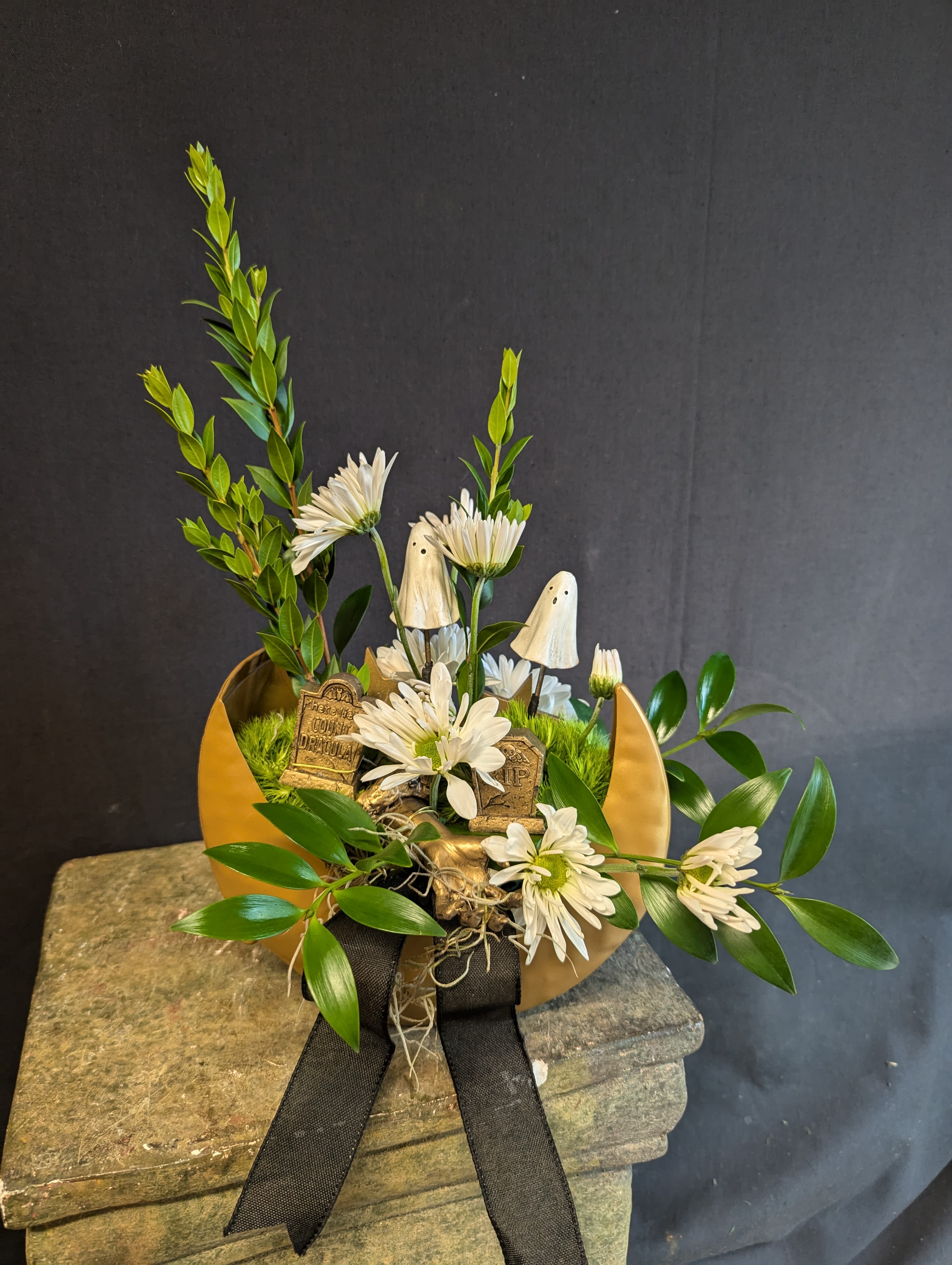Pushing Daisies Bouquet  - Perfect for those celebrating an Over the Hill Birthday, our Pushing Daisies Bouquet includes white daisies accented with spooky graveyard decor and greenery. Arrives in a keepsake golden moon metal container.