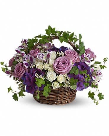 A Full Life - Even in mourning it is important to remember and honor a life well lived. This beautiful basket of purple and white flowers blended with vibrant greenery is a wonderful way to pay tribute to one who has indeed lived a full life. Brilliant flowers such as purple hydrangea, lavender roses, white spray roses and waxflower are arranged with beautiful ivy and more in a lovely round basket.