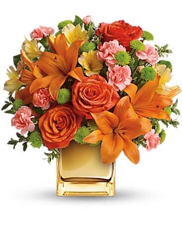 Teleflora's Tropical Punch Bouquet Teleflora's Tropical Punch Bouquet - Glow for it! Capture the magic of a tropical sunset with this gorgeously glowing bouquet. Lush lilies and roses in radiant shades of orange and yellow are presented in a golden Mirrored Cube for a touch of instant glam. Soft orange roses, asiatic lilies and miniature carnations are arranged with yellow alstroemeria and green button spray chrysanthemums. Delicate oregonia and pittosporum add contrast. Delivered in a Mirrored Cube.