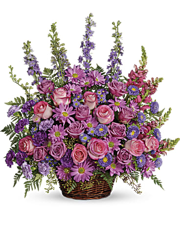 Gracious Lavender Basket - Soothing lavender, respectful purple and compassionate pinks are combined beautifully in this basket overflowing with pretty flowers, sincerity and sympathy. A lovely way to share your thoughts and pay tribute to someone special. A profusion of purple, pink and lavender blooms such as roses, carnations, larkspur, matsumoto and monte cassino asters and much more are delivered in a round wicker basket.