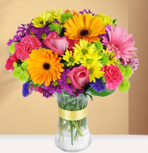 Joy that Shines Joy that Shines - bursts with color and joy, featuring a lively mix of orange gerbera daisies, cheerful alstroemeria, and bright carnations. This bouquet embodies happiness and positivity, perfect for lifting spirits or celebrating life’s joyful moments. Each bloom brings its own unique color, creating a beautiful rainbow effect that will brighten any room