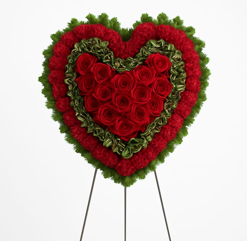 Majestic Heart - Remember a loved one's generous heart with this red arrangement in a classic heart shape, a declaration of eternal love and devotion. Solid red roses matched with deep red carnations are surrounded by variegated greens and fern.  