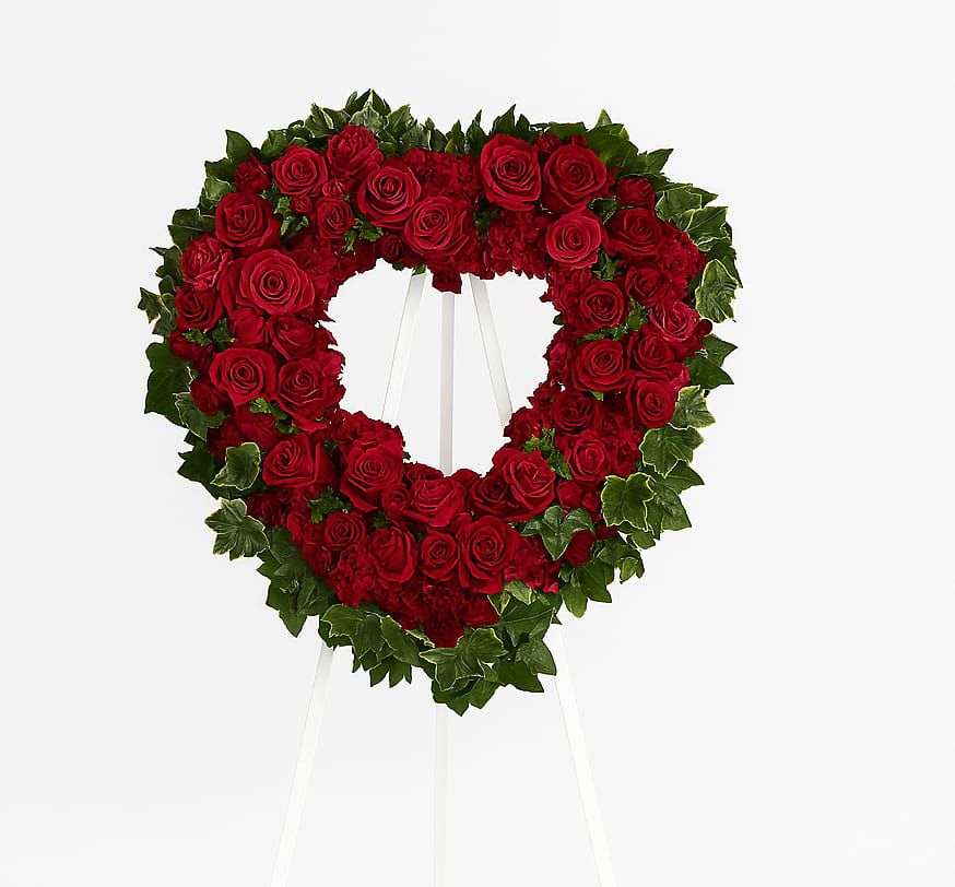 Blessed Heart - A beautiful heart is a wonderful way to share your thoughts of love. Red roses, spray roses, carnations and miniature carnations are arranged with fern and ivy in the shape of a heart.
