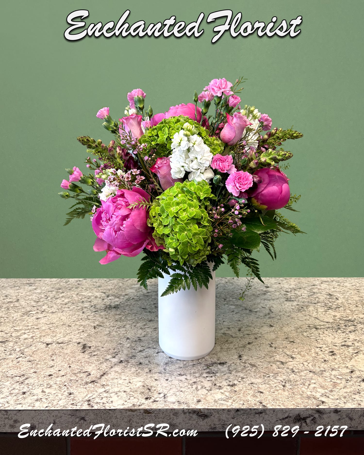 Punchy &amp; Pink - Seasonal Arrangement - A striking mixed arrangement showcasing a vibrant hot pink, green, and white palette. Featuring an array of premium peonies, blended with roses, hydrangeas, snapdragons, mini carnations, and stock. Accented with wax flowers, lush lemon leaves, and leather ferns. Presented in a sleek, white ceramic cylinder vase.  This vibrant mixed arrangement is perfect for brightening someones day, or adding a pop of color to any room.  Arrives In: White ceramic cylindrical vase  Orientation: Any-Sided  Approximate Dimensions: 18&quot; Tall 14&quot; Wide 3&quot; Vase Diameter