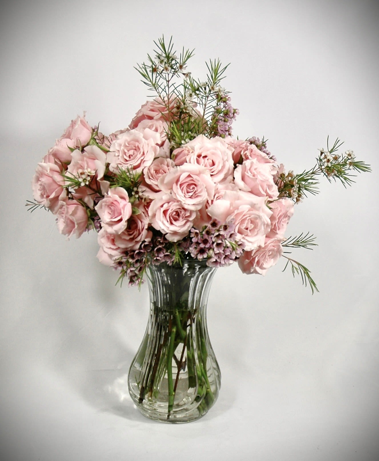 Pink Power - Confident, bold, and unapologetically feminine — Pink Power makes a statement with every petal. Overflowing with luxurious pink or white roses and accented by delicate pink wax flowers, this monochromatic masterpiece radiates strength and beauty. Perfect for celebrating powerful women, milestones, or simply embracing the color of love and grace, Pink Power is where elegance meets empowerment.  Vase subject to change