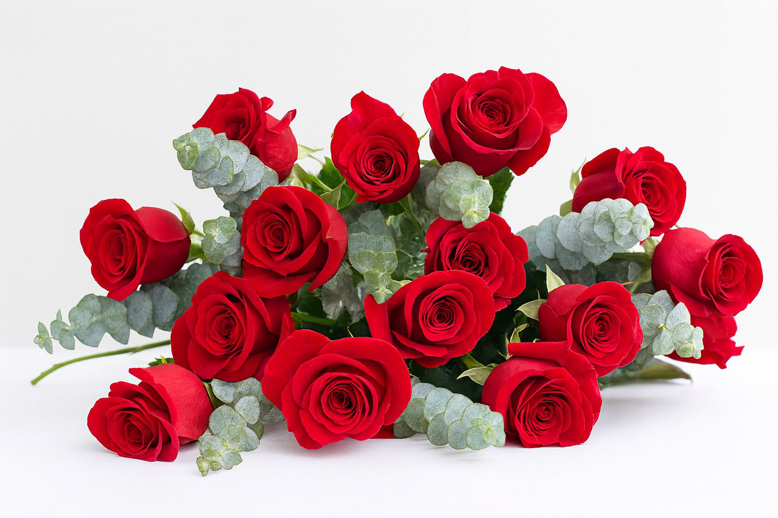 Classic Handtied Dozen Rose Bouquet - This is a classic handtied rose bouquet. Standard size comes with a dozen red roses with fillers and greens. Deluxe size includes 2 dozen red roses with fillers and greens. Premium size includes 3 dozen red roses with fillers and greens. 