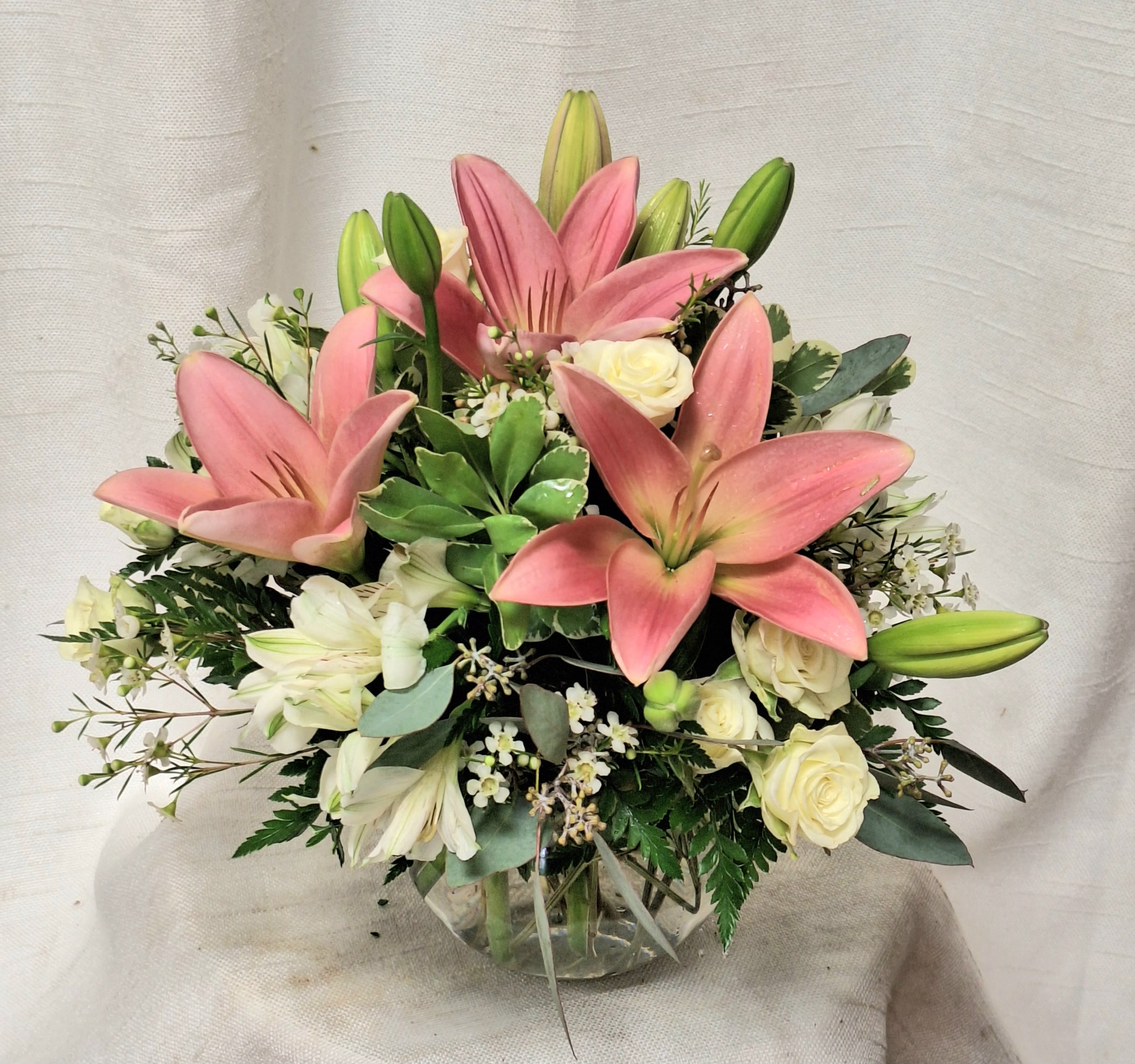 Mother Of Pearl (BB) - A beautiful bubble arrangement, featuring pink lilies, white and green roses, and more, this arrangement is the perfect all-occasion gift. Pearls are the birthstone of June making this a great option for an early summer birthday!