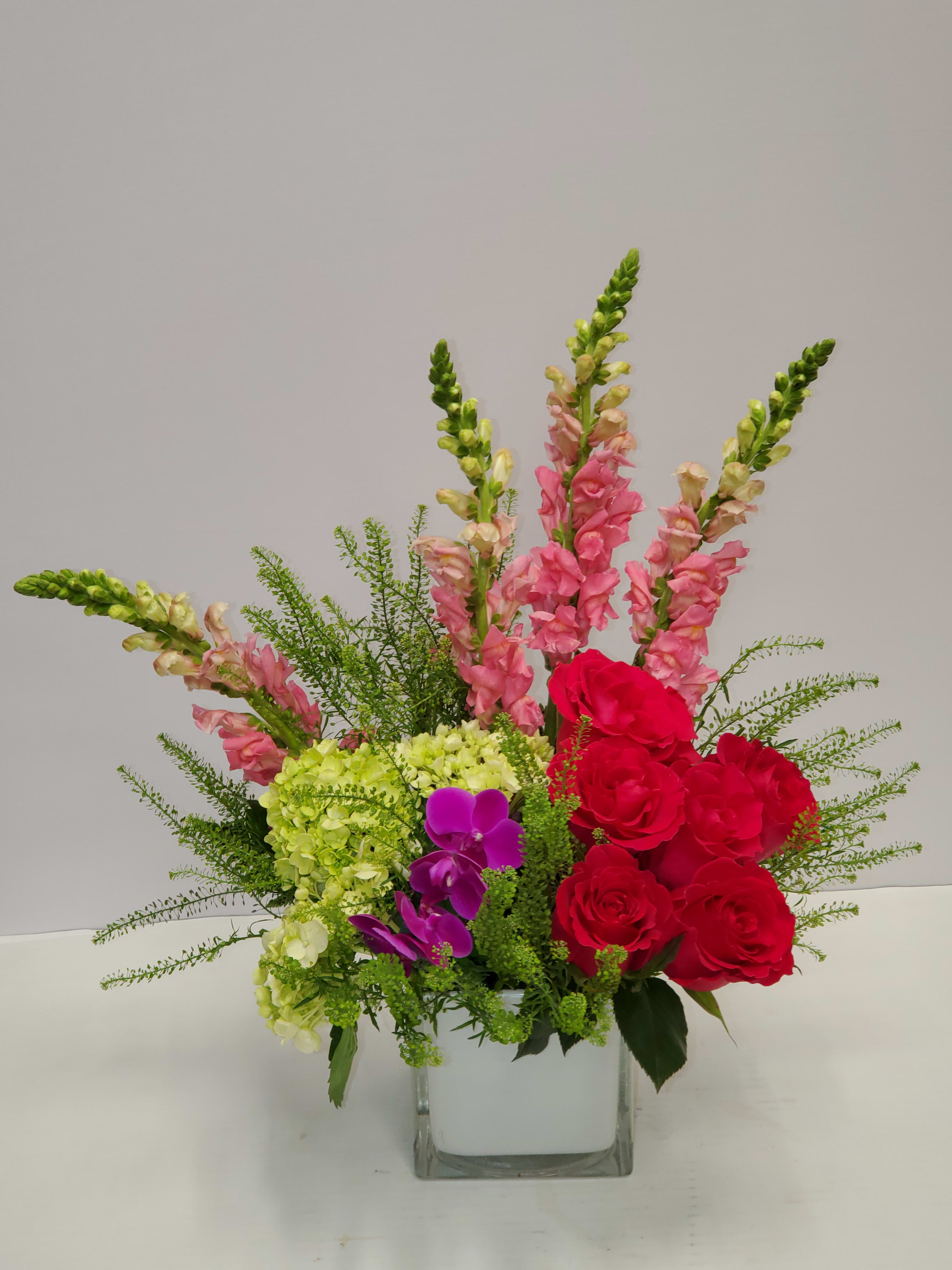 Take Me Away  - Escape to paradise with this lush and vibrant bouquet. This arrangement contains Cymbidium Orchids, Bells of Ireland, Snapdragon, Roses, and Button Mums. This is the perfect gift for a birthday, congratulations, or to celebrate new beginnings.