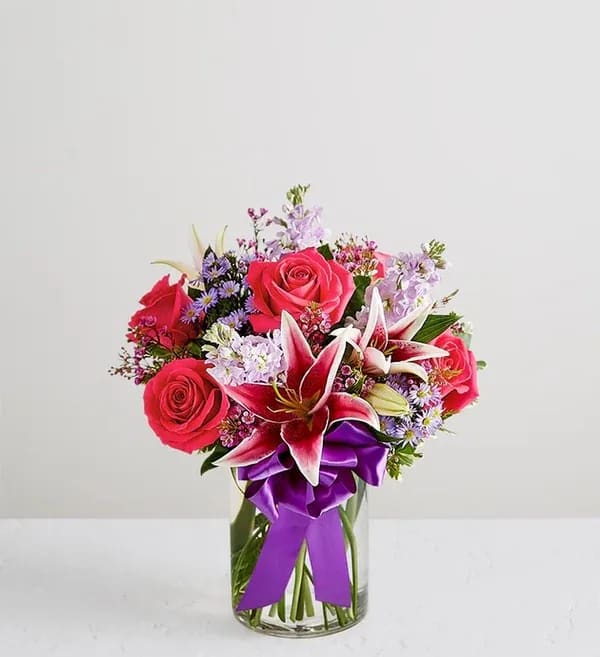 Straight From The Heart  - A gift means so much more when it comes from the heart. Our Valentine’s bouquet delivers on that sentiment, with radiant pink and purple blooms arranged in a glass vase. Finished with a purple satin ribbon, it’s a surprise that speaks volumes about how you feel.  All-around arrangement with hot pink roses, pink Stargazer lilies, lavender stock, purple waxflower and monte casino; accented with assorted greenery Extra large arrangement measures approximately 23&quot;H x 18&quot;W Large arrangement measures approximately 22&quot;H x 17&quot;W Medium arrangement measures approximately 21.5&quot;H x 16.5&quot;W Small arrangement measures approximately 21&quot;H x 16&quot;W Artistically designed in a clear glass cylinder vase; extra large/large vase measure 12&quot;H; medium/small vase measures 8&quot;H Our florists hand-design each arrangement, so colors, varieties and container may vary due to local availability To ensure lasting beauty, Stargazer lilies may arrive in bud form and will fully bloom over the next few days Bloom Details 
