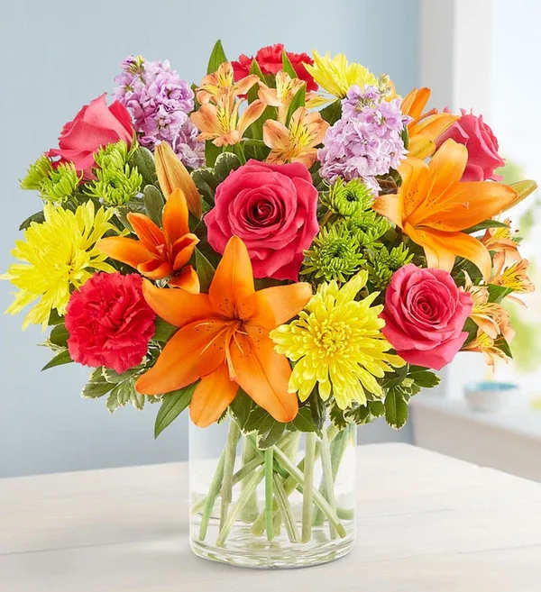 Vibrant Beauty Bouquet (exquisite) Vibrant Beauty Bouquet (exquisite) - A gift to match their vibrant personality. Our must-send bouquet is designed with a bold gathering of blooms—yellow, hot pink, orange, and lavender—bringing beauty and brightness to the big, small, and in-between moments. All-around arrangement with hot-pink roses and carnations, orange Asiatic lilies and Peruvian lilies (alstroemeria), yellow cremons, lavender stock, and Athos poms, accented with assorted greenery Extra-large arrangement measures approximately 16"H x 12"W Large arrangement measures approximately 15"H x 11"W Medium arrangement measures approximately 13"H x 10"W Small arrangement does not include stock or roses; includes monte casino; measures approximately 12"H x 9"W Artistically designed in a clear glass cylinder vase; extra-large and large vase measures 6"H; medium and small vase measures 5"H Our florists hand-design each arrangement, so colors, varieties and container may vary due to local availability To ensure lasting beauty, Asiatic and Peruvian lilies may arrive in bud form and will fully bloom over the next few days