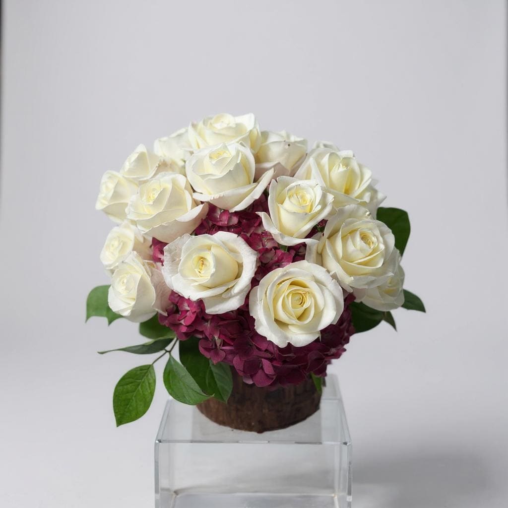 Pure Elegance - Bold beauty meets timeless sophistication in Pure Elegance. This stunning arrangement features lush, oversized hot pink hydrangeas paired with two dozen pristine white roses, all nestled among rich lemon leaf accents for a touch of natural greenery.  The dramatic contrast of vibrant pink and crisp white creates a striking visual statement—perfect for upscale events, heartfelt celebrations, or anyone who appreciates floral artistry at its finest.  Chic. Sophisticated. Unapologetically elegant.  Vase Subject to Change