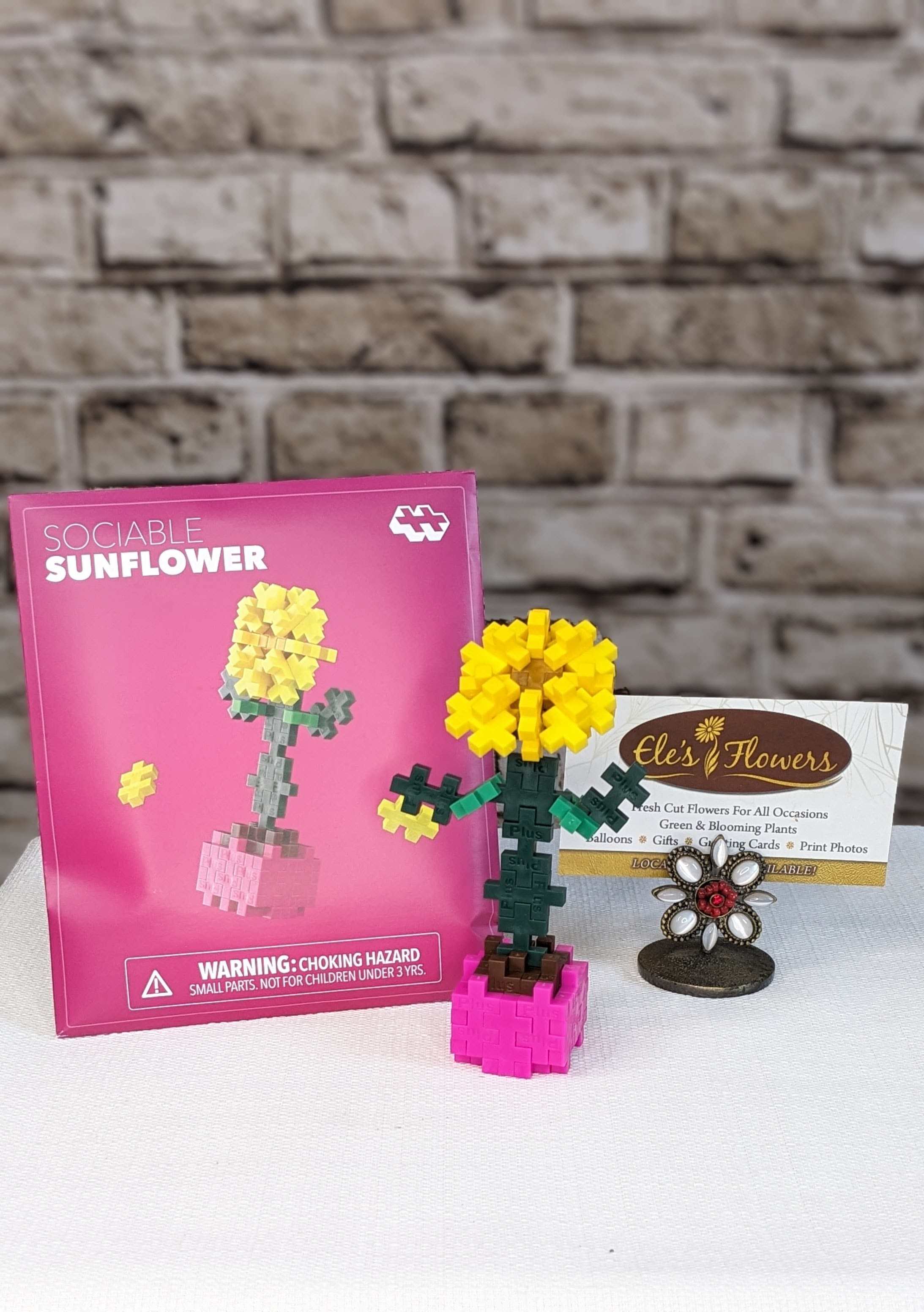 Sociable Sunflower - Plus Plus - Bring a burst of sunshine to your day with this cheerful build in warm shades of brown, yellow, green, forest, mustard, fuchsia, and copper. Simple to create and full of personality, this nature‑inspired project is perfect for sparking imaginative play and hands‑on creativity—just open, build, and watch your Sociable Sunflower smile back at you.  Packaged like a charming springtime seed packet, it’s ideal for on‑the‑go fun, party favors, or a little “just because” gift. Each pack includes a themed mat so your sunflower can stand tall and bright on display, no watering required, just sunny vibes all year long!  Suggested for ages 5+