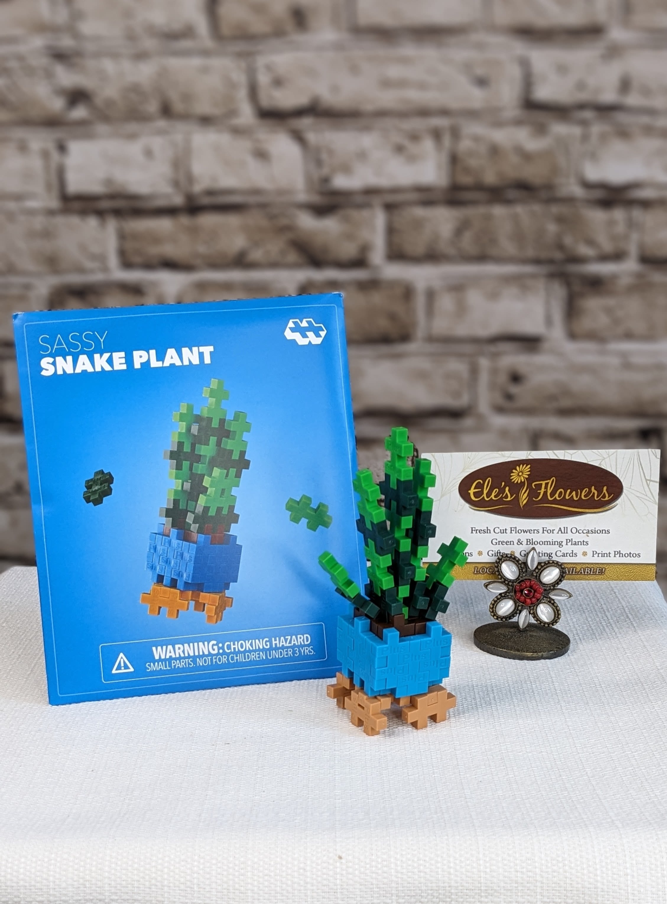 Sassy Snake Plant - Plus Plus - This bold and stylish Sassy Snake Plant pops in earthy shades of brown, forest, apple, camel, and ocean. Perfect for bringing a touch of greenery (and personality!) to your playtime. Simple to create and endlessly fun, this nature‑inspired project sparks imagination and hands‑on learning. Just open, build, and let your creativity slither into bloom!  Packaged like a charming springtime seed packet, it’s perfect for on‑the‑go fun, party favors, or a quirky little gift. Each pack includes a themed mat so your snake plant can stand tall and sassy on display, no watering needed, just a dash of attitude!  Suggested for ages 5+