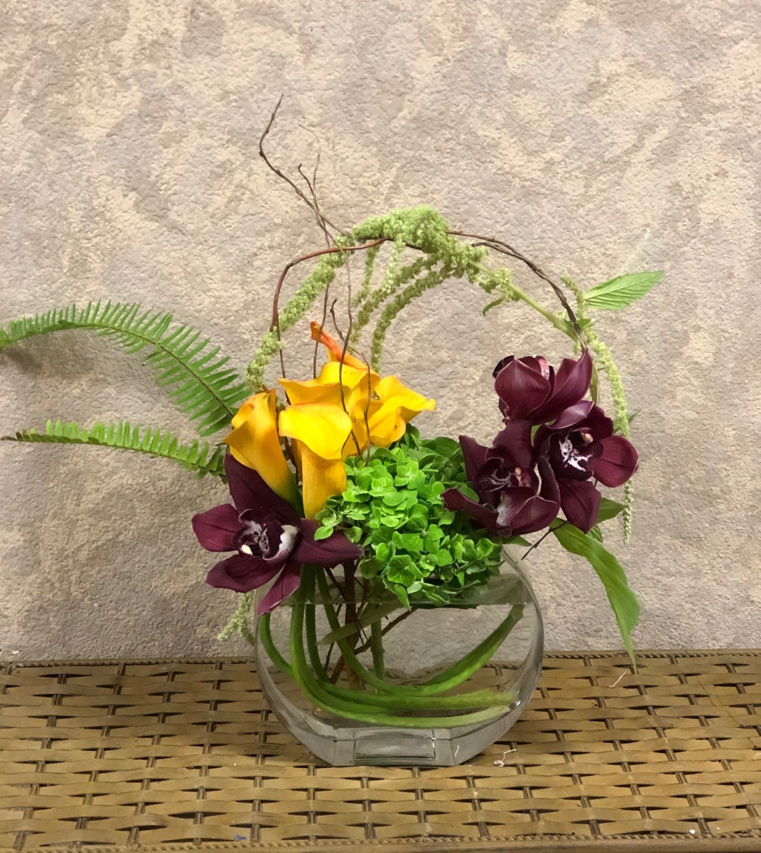 Whimsical Arches Whimsical Arches - Recipe: Yellow Calla Lilies, Green Hydrangeas, Purple Cymbidium Orchids, Green Hanging Amaranthus, Fern, and Branches in a pillow vase. Availability: All year round Substitute Available: Yes Design View: All Facing View Photo shown: Regular