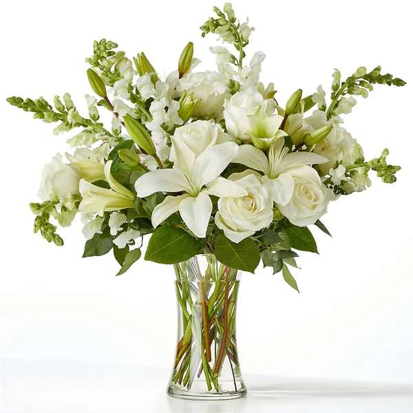 Eternal Friendship Bouquet (exquisite) Eternal Friendship Bouquet (exquisite) - An exuberance of bright and beautiful white blossoms provides an exquisite way to deliver your expressions of sympathy and comfort. This life affirming tribute combines white roses, snapdragons and Asiatic lilies accented by lush greens arranged in a clear glass 8" vase. An excellent choice for a wake, funeral service or for sending your condolences to the home of grieving family or friends. Details Approx. 18" H x 15" W