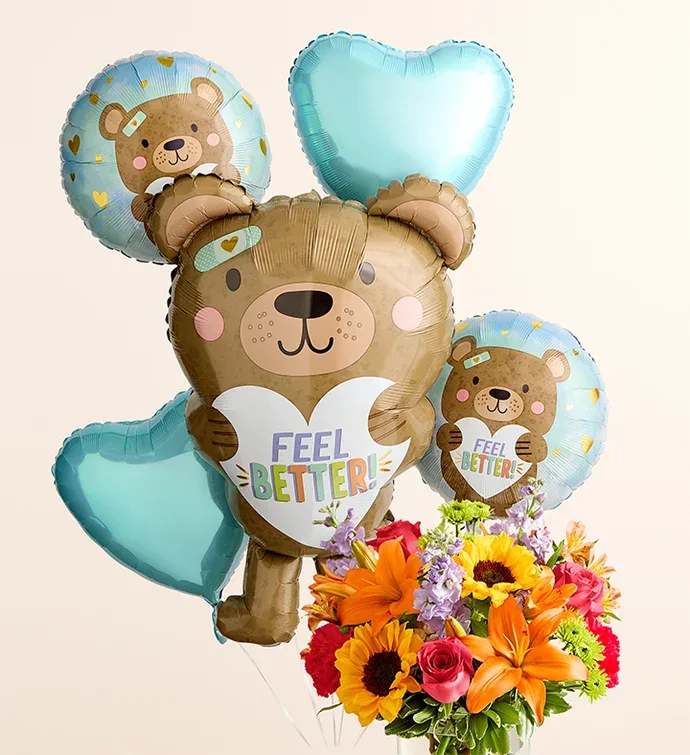 Floral Embrace™ with Feel Better Bear Balloon Bouquet (extra large) Floral Embrace™ with Feel Better Bear Balloon Bouquet (extra large) - All-around arrangement with hot pink roses and carnations; orange Asiatic lilies and Peruvian lilies (alstroemeria); yellow sunflowers; lavender stock; purple monte casino; green Athos poms; accented with assorted greenery Extra-large arrangement measures approximately 16"H x 12"W Large arrangement does not include monte casino; measures approximately 15"H x 11"W Medium arrangement does not include monte casino; measures approximately 13"H x 10"W Small arrangement does not include roses; measures approximately 12"H x 9"W Artistically designed in a clear glass cylinder vase; large vase measures 6"H; medium/small vase measures 5"H