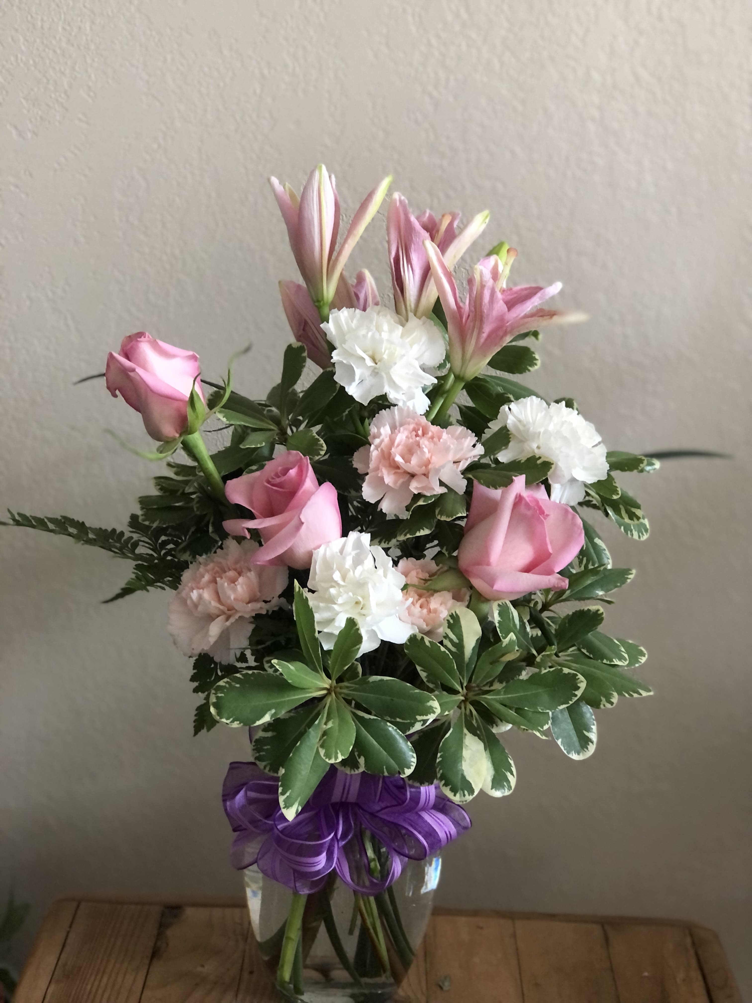 Roses, Carns and Lilies, OH MY! - Does someone you know need a pick-me-up? Lift their spirits – and make the day special – by sending this charming display of blushing blossoms in shades of pink, red and purple. It’s the perfect all-occasion, fresh-from-the-garden bouquet.