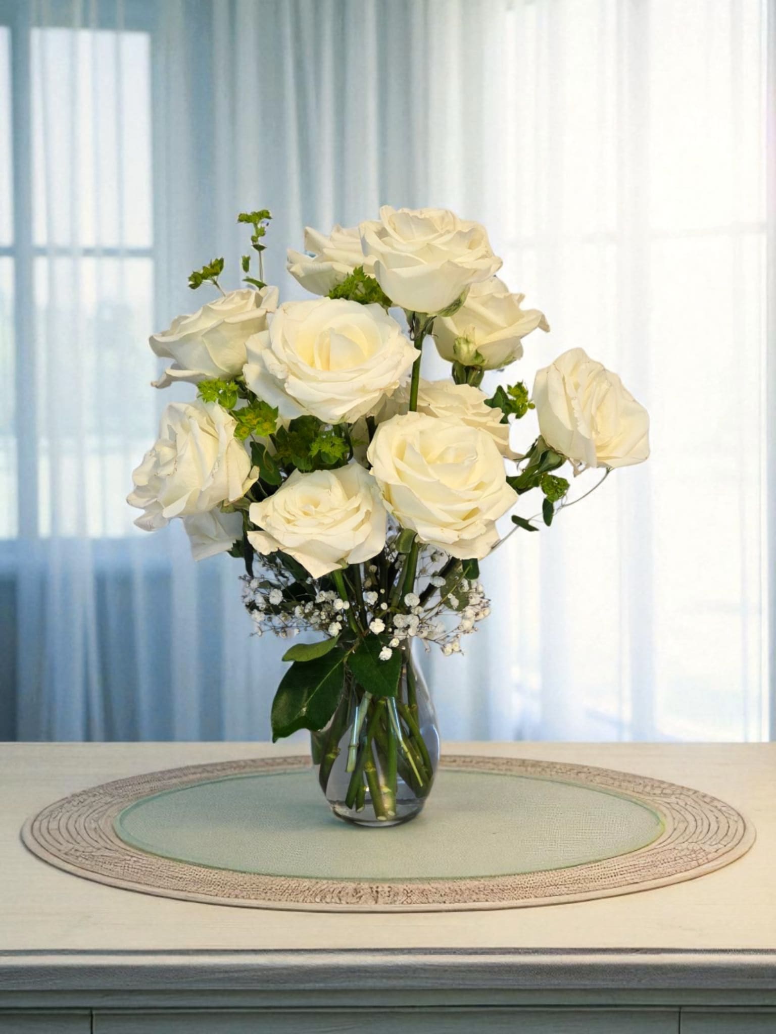 1 Dozen White Roses - Designer's Style - A dozen white roses - pure and graceful, their delicate petals unfurl like soft ivory satin. Symbolizing innocence, reverence, and everlasting love. Gathered together they create a serene and sophisticated arrangement with gentle refinement.  Approximate Dimensions: 24&quot;H x 12&quot;W