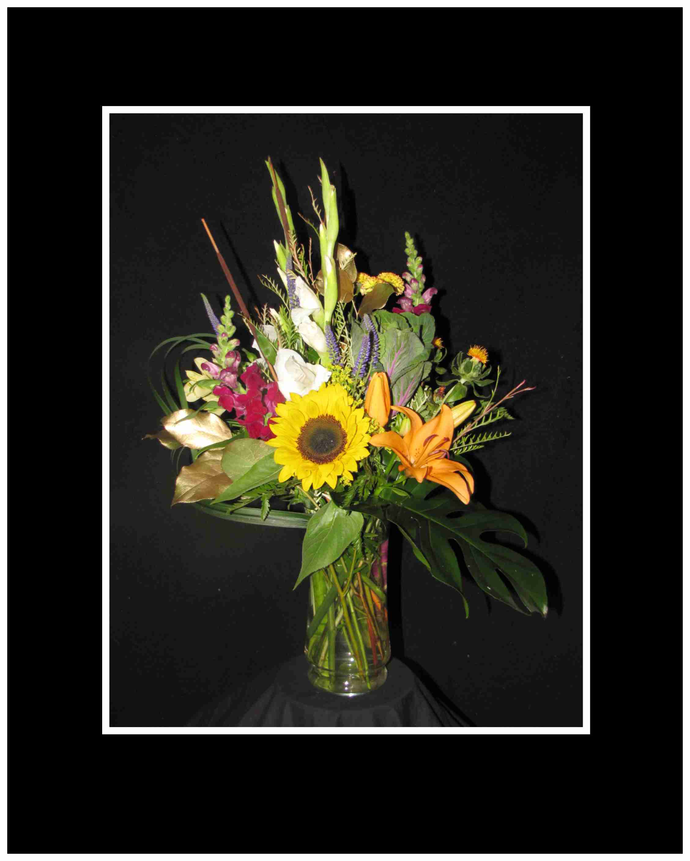 Harvest Delight Bouquet Harvest Delight Bouquet - A showy sunflower with glads ,snaps and kale, foliage and mums, and many other interesting fall flowers, so lots of fall colors to finish this harvest time arrangement, Approximately 18" High