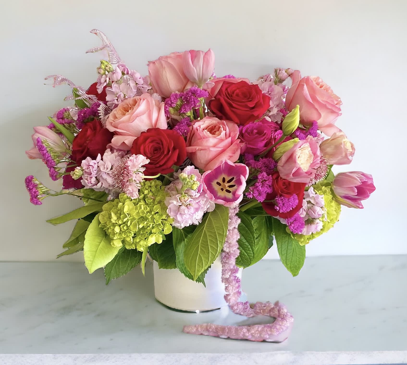 Flirty Pinks - Shades of pink flowers in a lush arrangement. Designed and hand-crafted with a variety of seasonal, fresh, high-end flowers in a Pink palette. Container is a 6&quot; ceramic white vase. Pictures are not exact duplicates of what we will be making, but rather are samples of our creations and design style. However we will make every effort to stock and use flowers shown. All arrangements will be DESIGNERS CHOICE based on flower availability in the particular COLOR PALETTE you are choosing. For same day delivery, call us at 949-682-5004.
