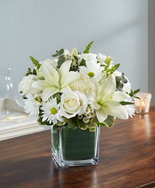 Healing Tears In White Healing Tears In White - Healing Tears in White is a beautiful mix of White flowers and Greenery in a leaf lined cube vase. This arrangement is available in 3 sizes and has roses in the Medium and Large Sizes only.
