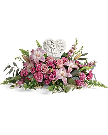 Teleflora's Heartfelt Farewell Bouquet - A heartfelt celebration of a truly special life, this magnificent bouquet of pink roses and lilies beautifully surrounds a touching porcelain keepsake they'll treasure forever. This heartfelt bouquet includes pink roses, pink spray roses, pink asiatic lilies, pink carnations, pink larkspur, green ivy, seeded eucalyptus, silver dollar eucalyptus, and sword fern. Delivered with a Heaven's Heart Keepsake. Orientation: One-Sided  SUBSTITUTION POLICY – Always deliver the freshest flowers! Please note the bouquet pictured reflects our original design.  If the exact flowers or container in this arrangement are not available, our local florists will create a beautiful bouquet with the freshest available flowers. T280-8A