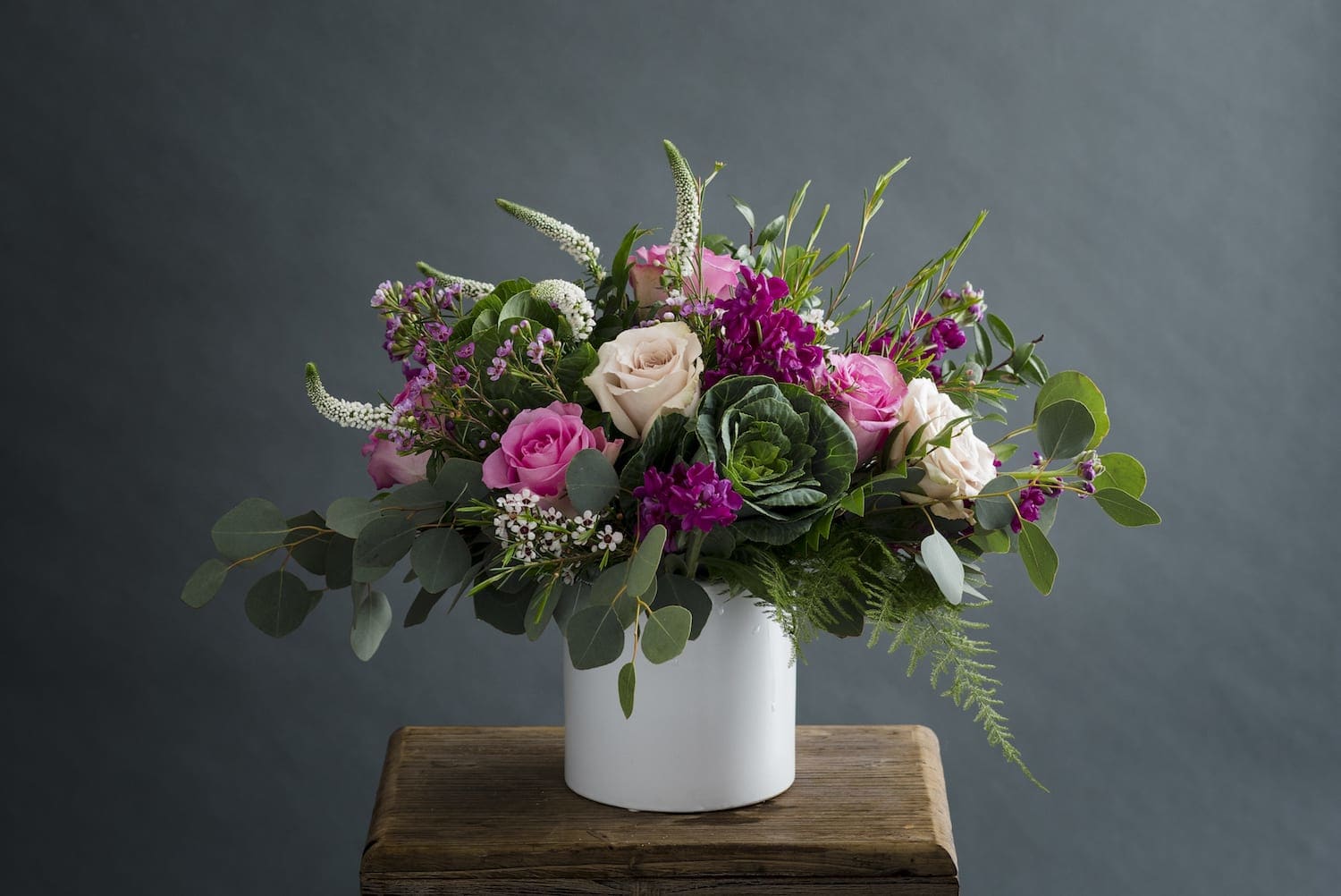 Whispering Garden - Gorgeous! Premium flower for a special person or occasion. Approximately 14&quot; high and 12&quot; wide. Roses in shades of pink and white with White Veronica creating a leggy, whimsical design. But, also, get this, ornamental Kale making this design garden fresh. A few small petal blooms add texture making this a &quot;to see&quot; design. 