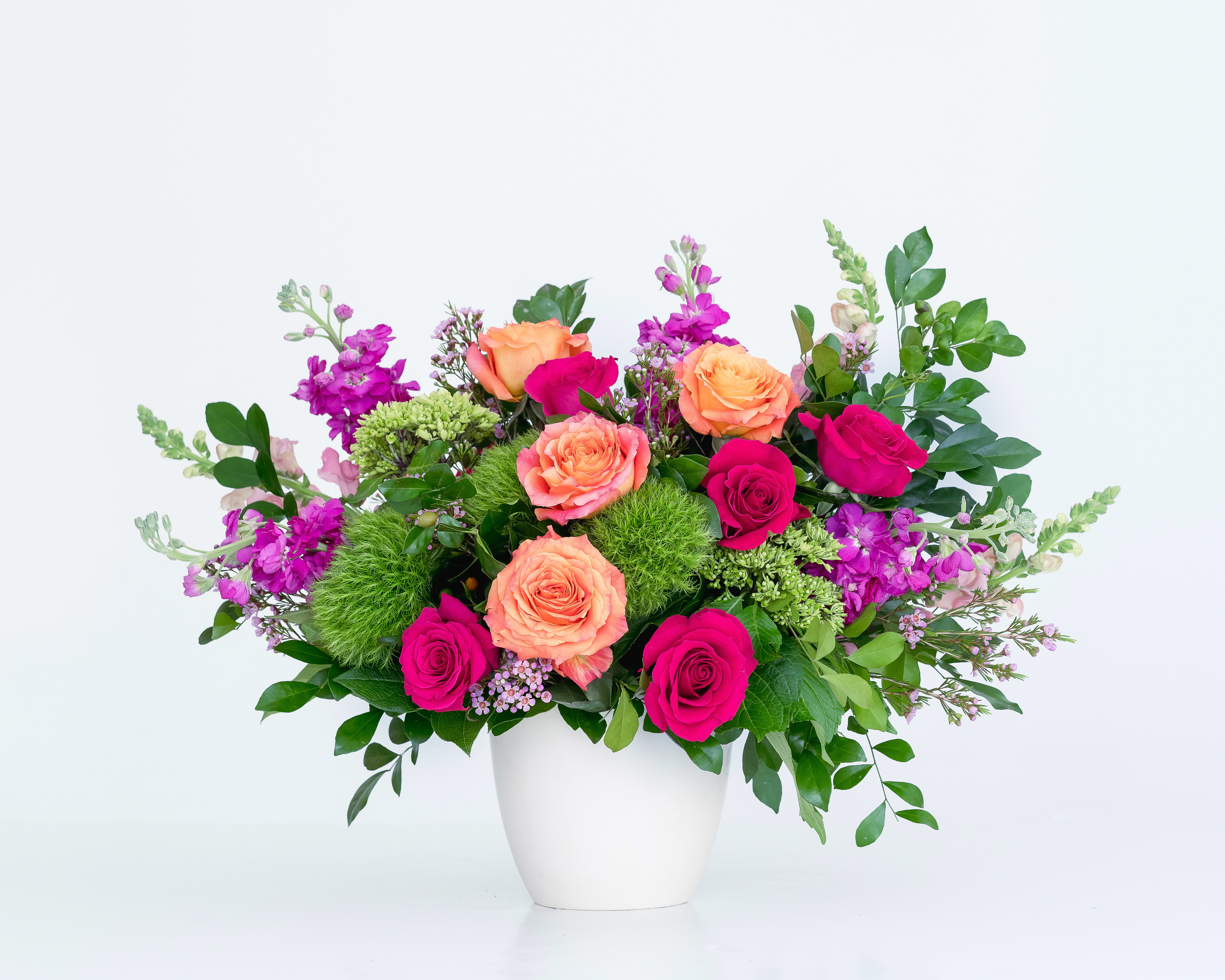 Celebration Collection - Signature Size - Radiance in vase - a stunning gathering of our most vibrant blooms. This large design in our Celebrate Collection boasts roses, garden roses, Stock, Snapdragons, Green Trick Dianthus, Waxflower and unique greenery - all nestled in a modern ceramic vase. This is sure to get the party bumpin'.  Arrangement is approximately 14&quot; tall and 14&quot; wide.  