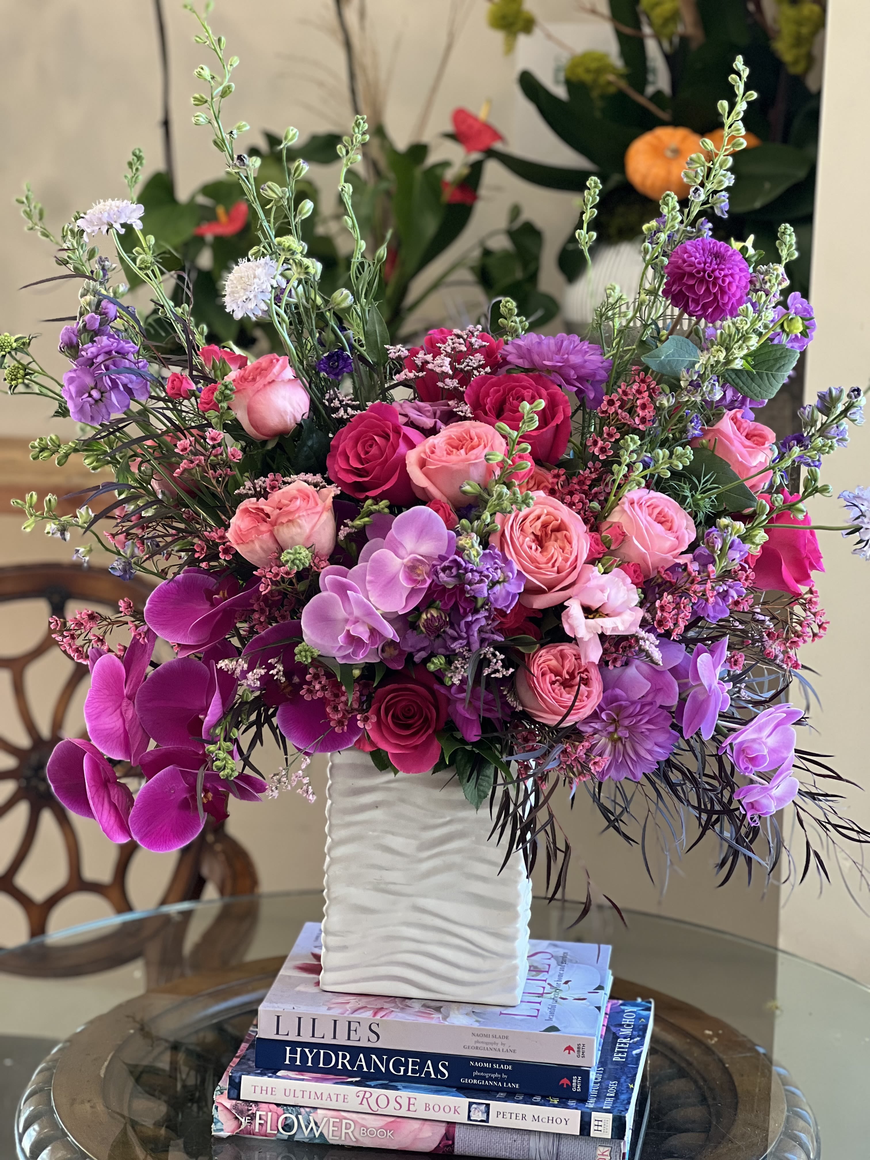 Amethyst Heart  Amethyst Heart  - Flowers: pink expression garden roses, purple orchids, lavender scabiosa, lavender stock, purple dahlias, purple larkspur, burgundy willow eucalyptus, pink floyd roses, mauve waxflower, and hot pink spray roses.   Designed in a white ceramic vase