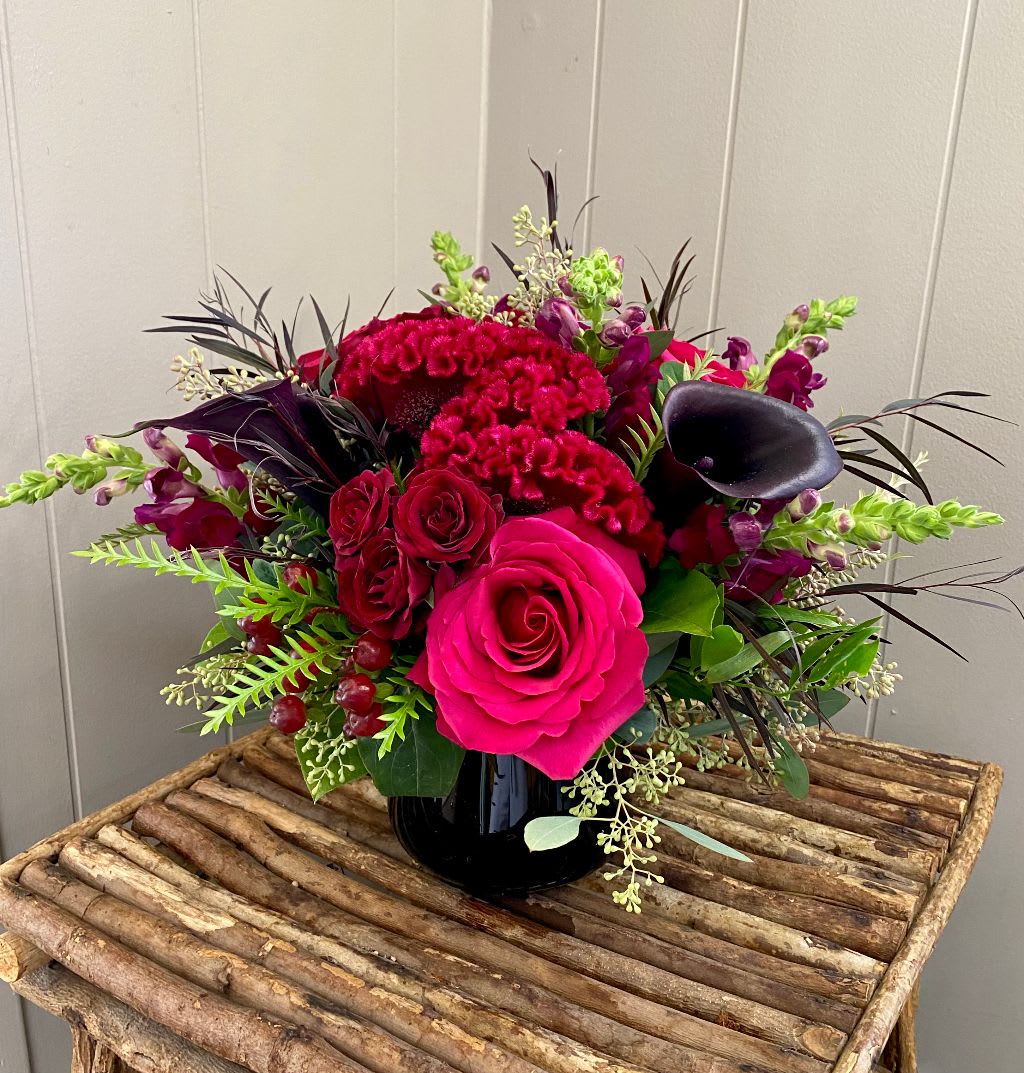 Witches Brew - This seasonal delight is crafted with jewel toned roses, spray roses, calla lilies, celosia, snapdragon, and more, all in a black vase! Please note we have to substitute the vase as pictured for a different black vase.