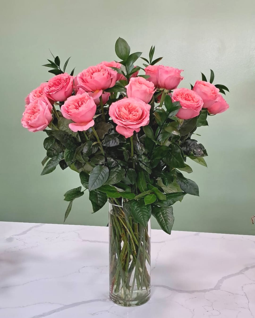 Coral Candy Coral Candy - This stunning arrangement has 24 long stem coral garden roses in a clear glass cylinder.