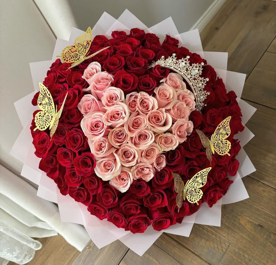 Corona de Amor: Ramo de Rosas Rosadas y Rojas con Mariposas -  Este impresionante arreglo floral es mucho más que un regalo; es una experiencia sensorial que cautiva los sentidos y despierta emociones profundas.  Las rosas, cuidadosamente seleccionadas por su frescura y belleza, irradian una elegancia natural que no pasa desapercibida. El contraste entre los tonos rosados y rojos crea una paleta de colores vibrante y cautivadora que atrae la mirada y llena el corazón de emoción.  La corona artesanal, con sus detalles meticulosos, y las mariposas danzantes añaden un toque de magia y distinción al ramo, elevando su belleza a nuevas alturas. Cada elemento de este arreglo ha sido diseñado para deleitar y sorprender, creando una experiencia que es simplemente irresistible.  Ya sea para celebrar un aniversario, expresar amor o simplemente para mimar a alguien especial, este ramo es el regalo perfecto. Su elegancia y su encanto único garantizan que sea recibido con alegría y admiración.  No espere más para sorprender a sus seres queridos con nuestro Exclusivo Ramo de Rosas Rosadas y Rojas. Una obra maestra floral que no solo deleitará los sentidos, sino que también robará corazones.