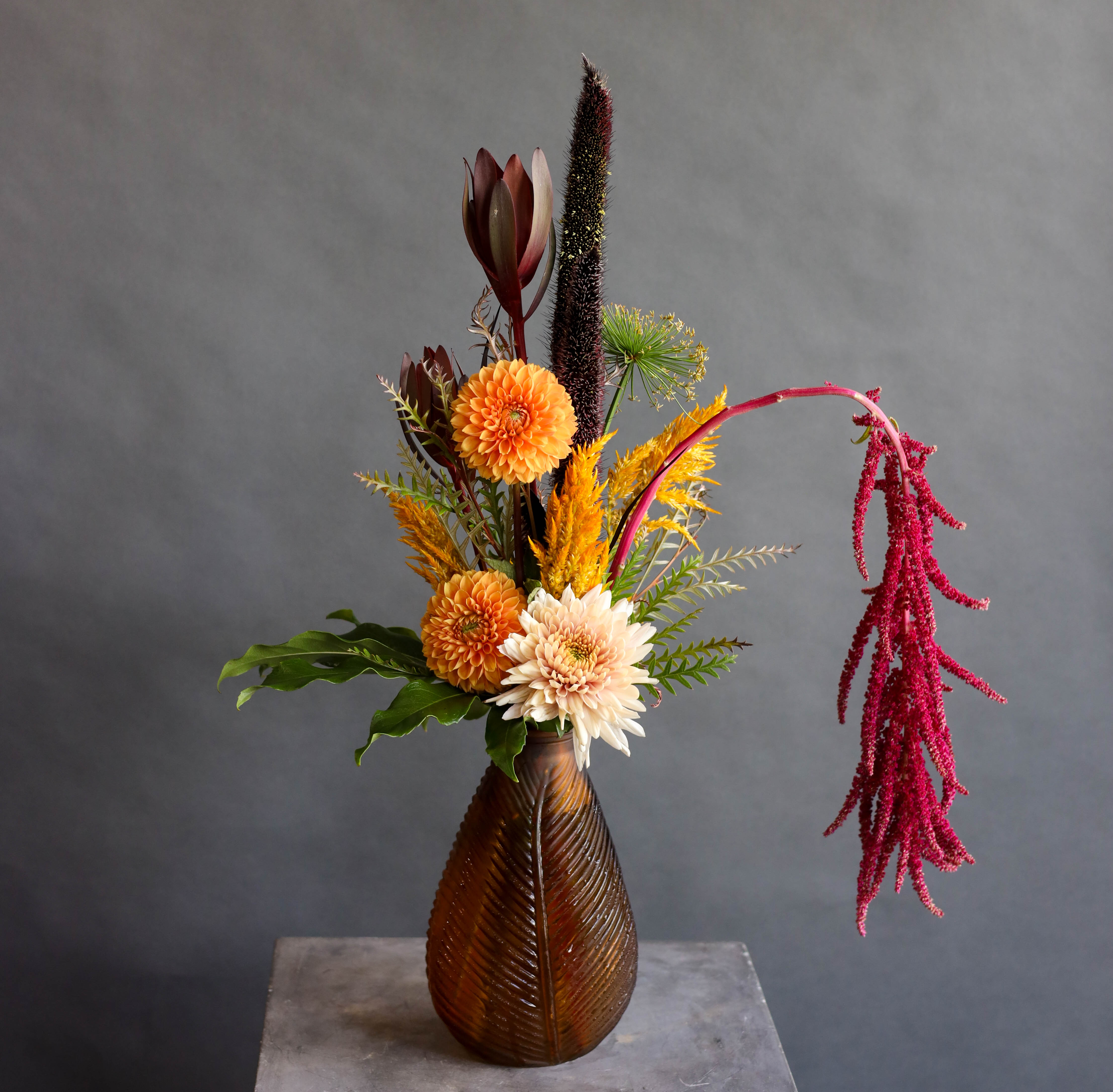 Amber - This arrangement in a deep amber glass vase not only embodies the characteristics of Amber, but the many shades of it, as well. It is the perfect fall color and embraces positivity, joy, security, warm, friendly, inspires and comforts. 