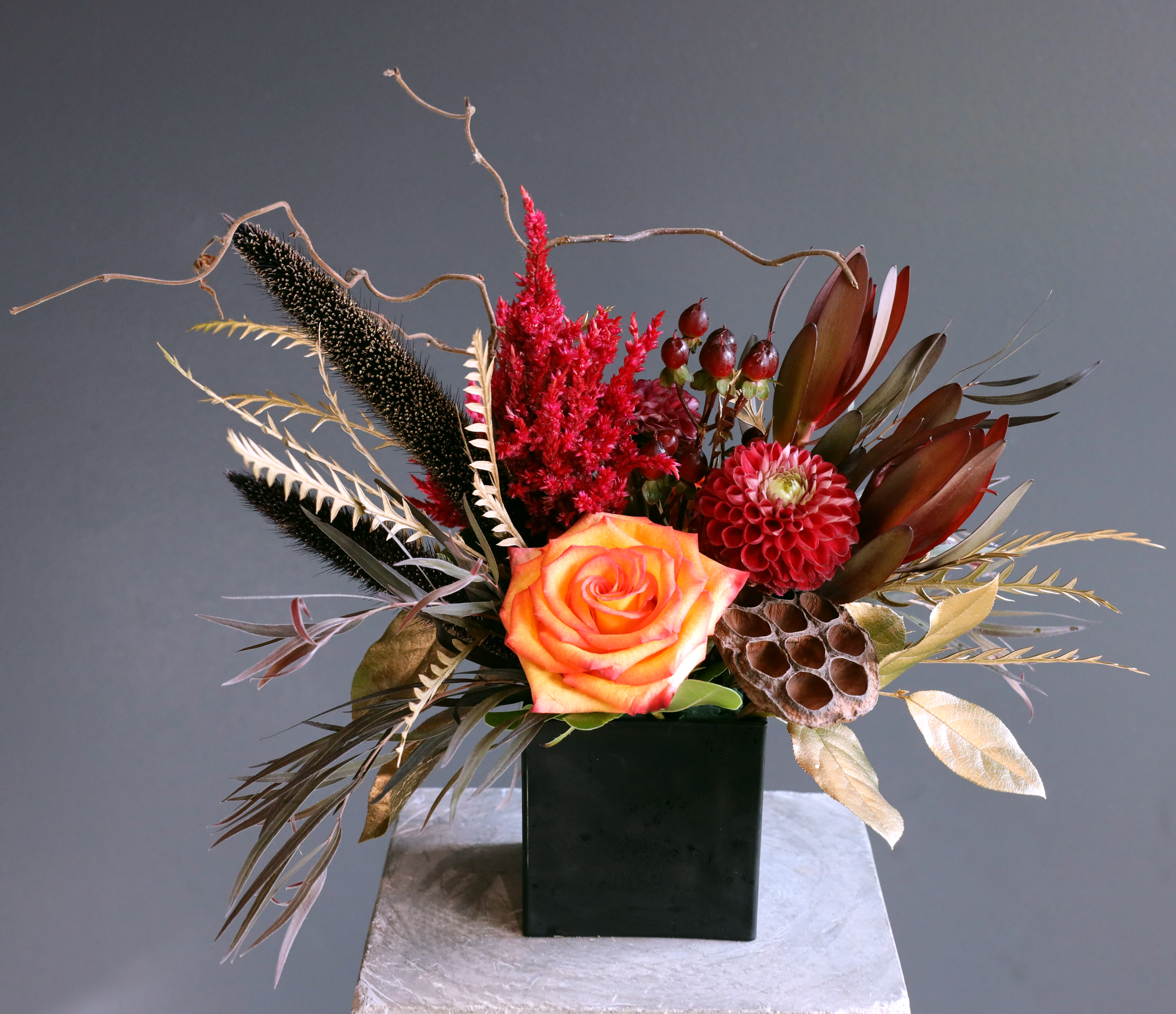 Burning Passion - A small but elegant and warm  arrangement artistically designed with fiery colors and rich golden accents!