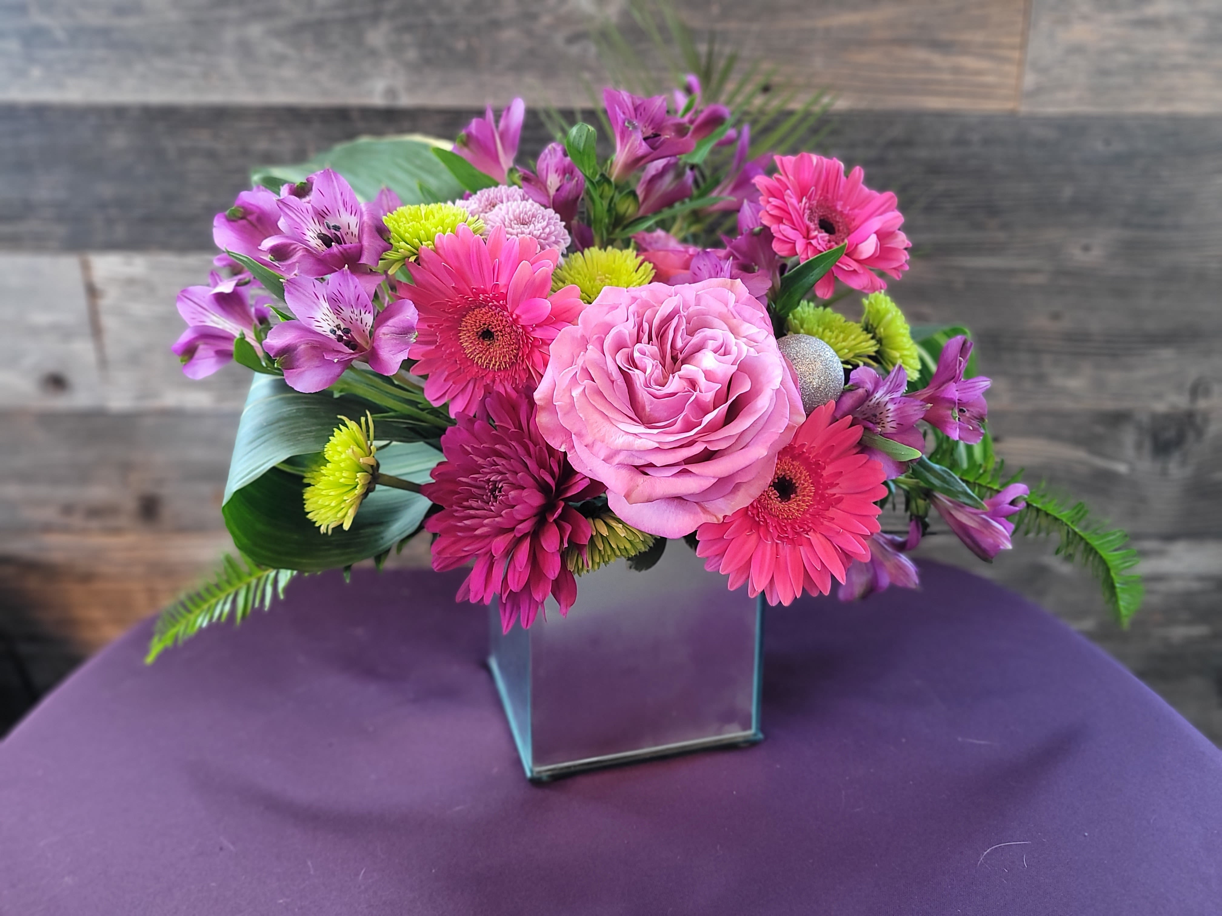 Groove Groove - A bold, lively arrangement in a sleek, reflective vase, with vibrant colors and polished accents that feel ready to move to the beat. An arrangement that feels like a favorite song — full of rhythm, color, and life. Ideal for celebrations, milestone events, or anyone who loves a statement piece with personality.