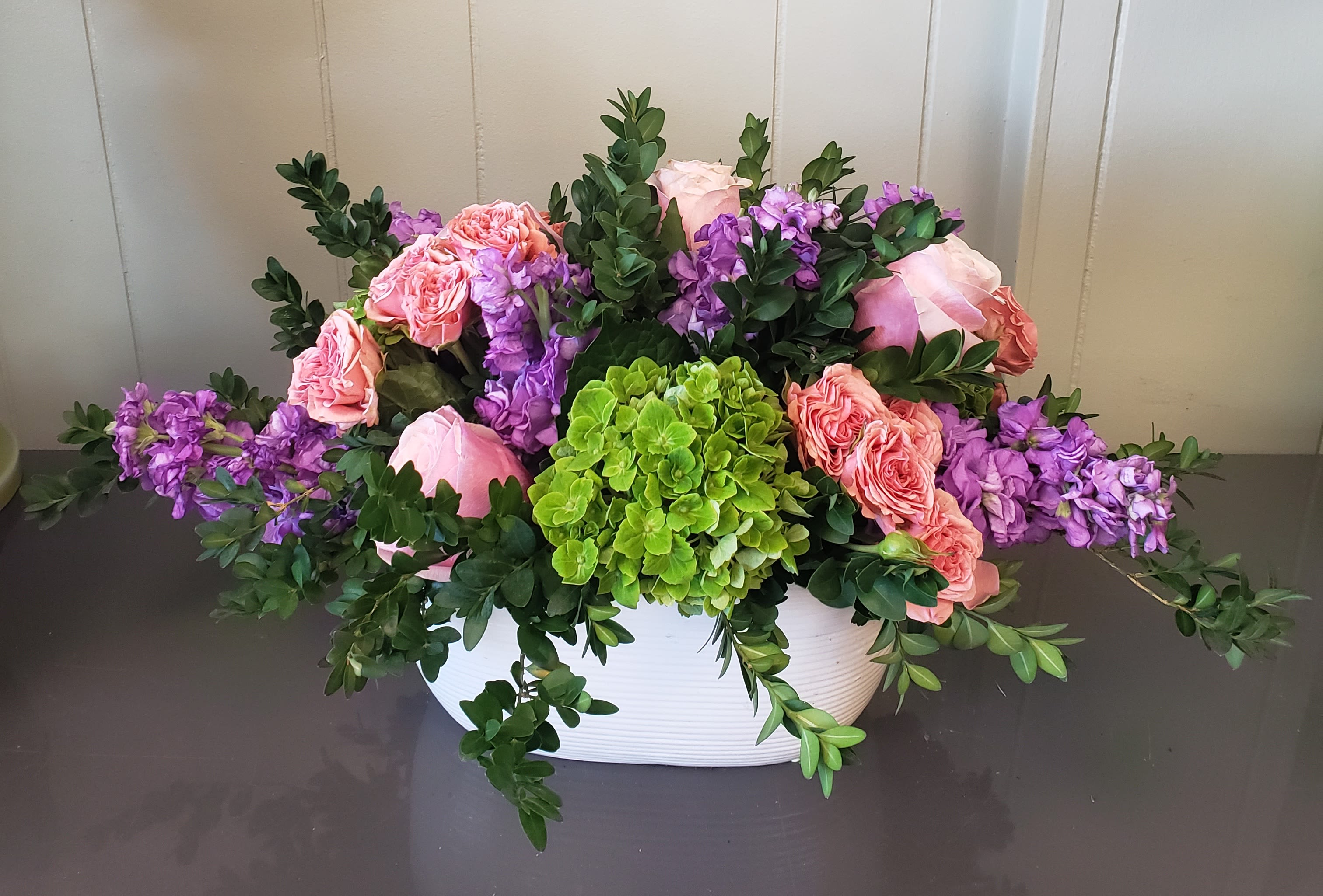 Weekly special Weekly special - Hydrangea, stock spray roses, filler and greenery sits in white ceramic vase.