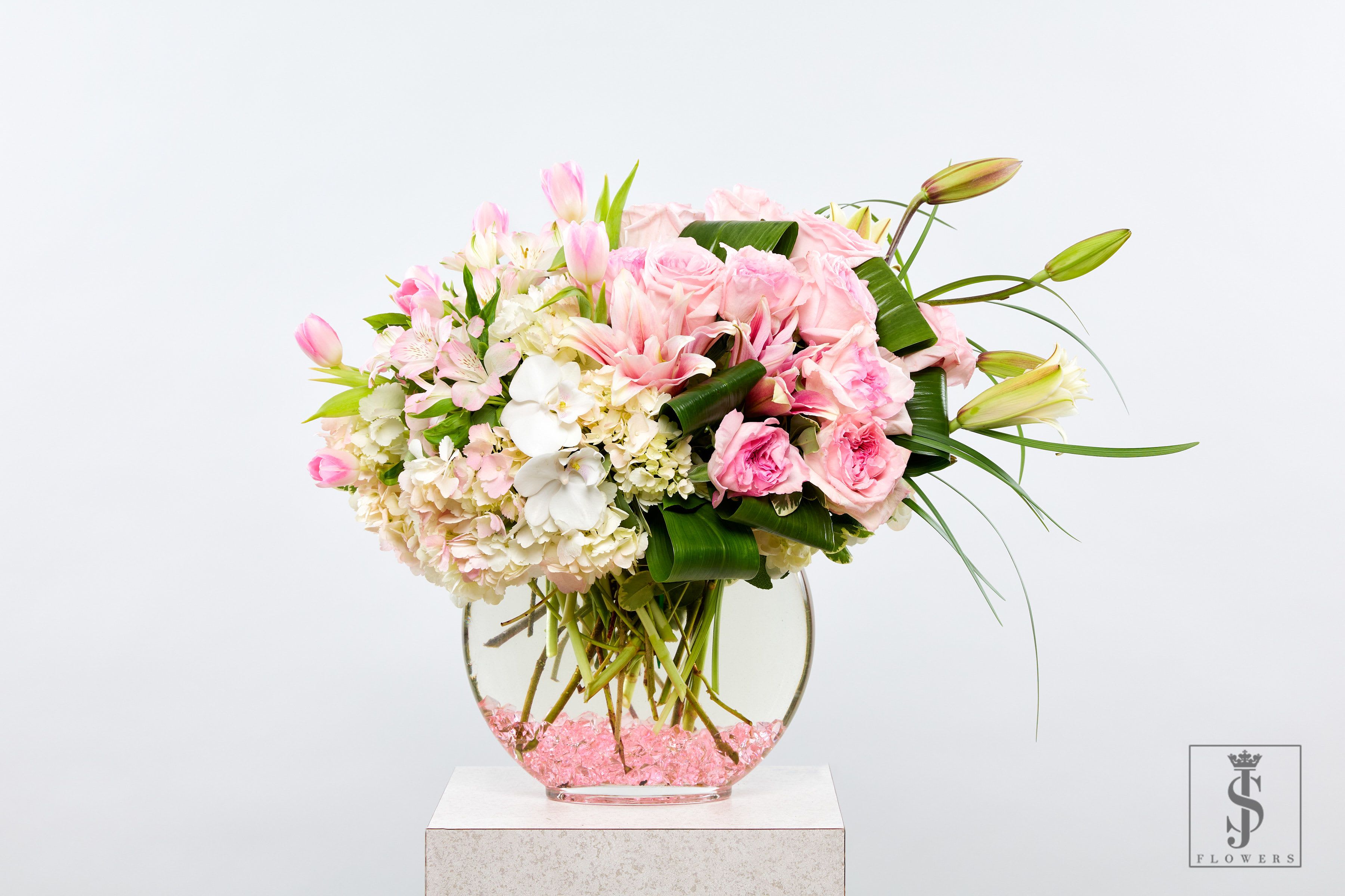 Pinky Promise -  Pinky Promise   It’s sweet, memorable, and emotional — perfect for an arrangement that’s thoughtful or tied to friendship and meaningful gestures yet soft and timeless—this luxurious flower arrangement blends blush pink roses, white orchids, lilies, and hydrangeas in a modern fishbowl vase with sparkling pink crystals. Designed to express elegance and grace, it's the perfect centerpiece for weddings, anniversaries, baby showers, sympathy gestures, or premium home décor. Hand-arranged with fresh blooms that add a touch of sophistication and charm to any space.  Now available for same-day delivery. Ideal for gifting, décor, and events.