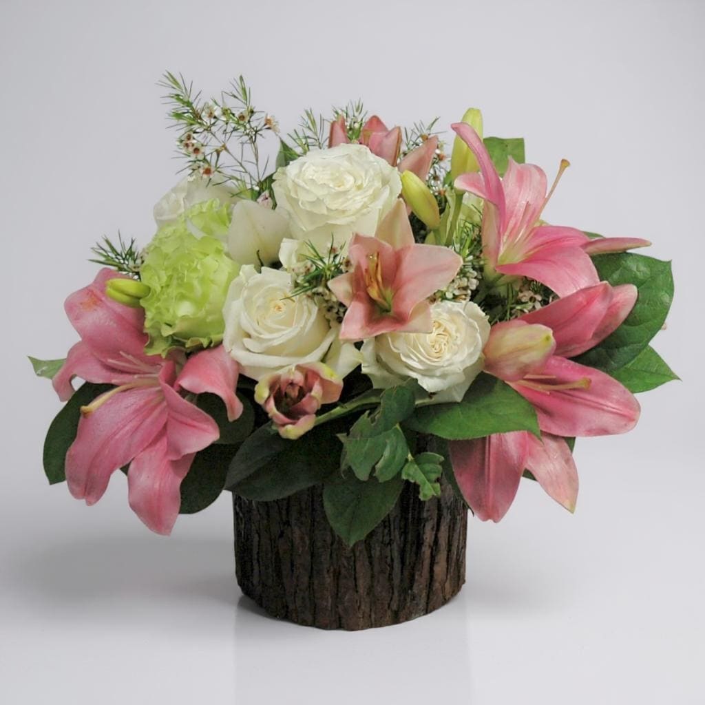 Summer Breeze - Fresh, light, and full of charm — Summer Breeze captures the essence of a perfect sunny day. This refreshing arrangement features a soothing mix of white and green roses, accented by elegant pink lilies, delicate wax flowers, and lush lemon leaf greenery. Its soft colors and airy design evoke feelings of relaxation and joy, making it an ideal gift for celebrations, get-well wishes, or simply brightening someone's space with a breath of floral freshness.  Vase subject to change