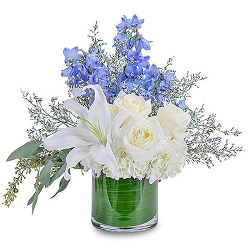 Calm and Cool - Beautiful handcrafted arrangement designed with, White Lilies, White Roses, White Hydrangeas, Blue Delphinium, and Limonium.