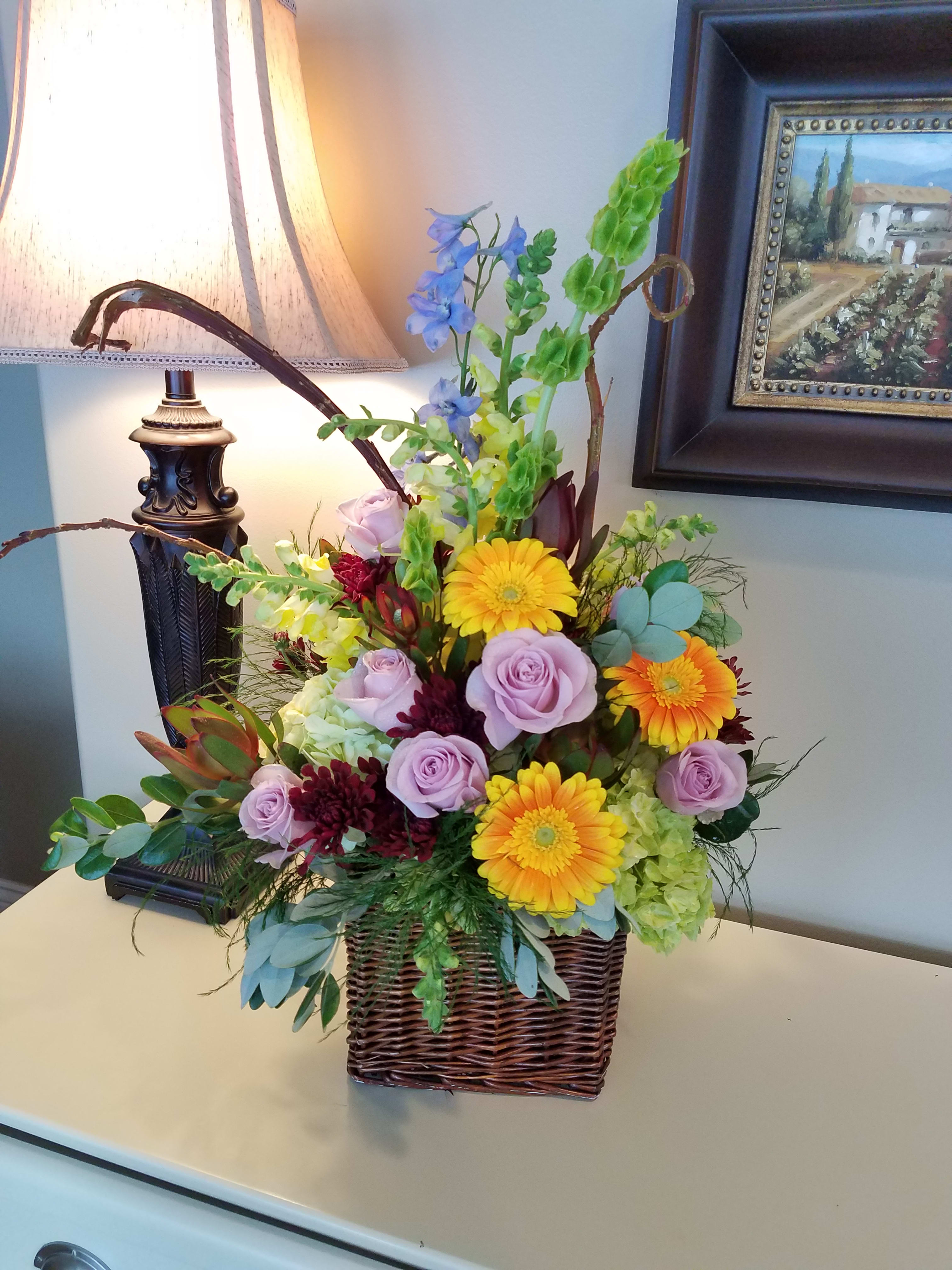 Sunlit Garden - A bold, Fresh design with beautiful pops of color and a touch of whimsy bring this arrangement to life. 