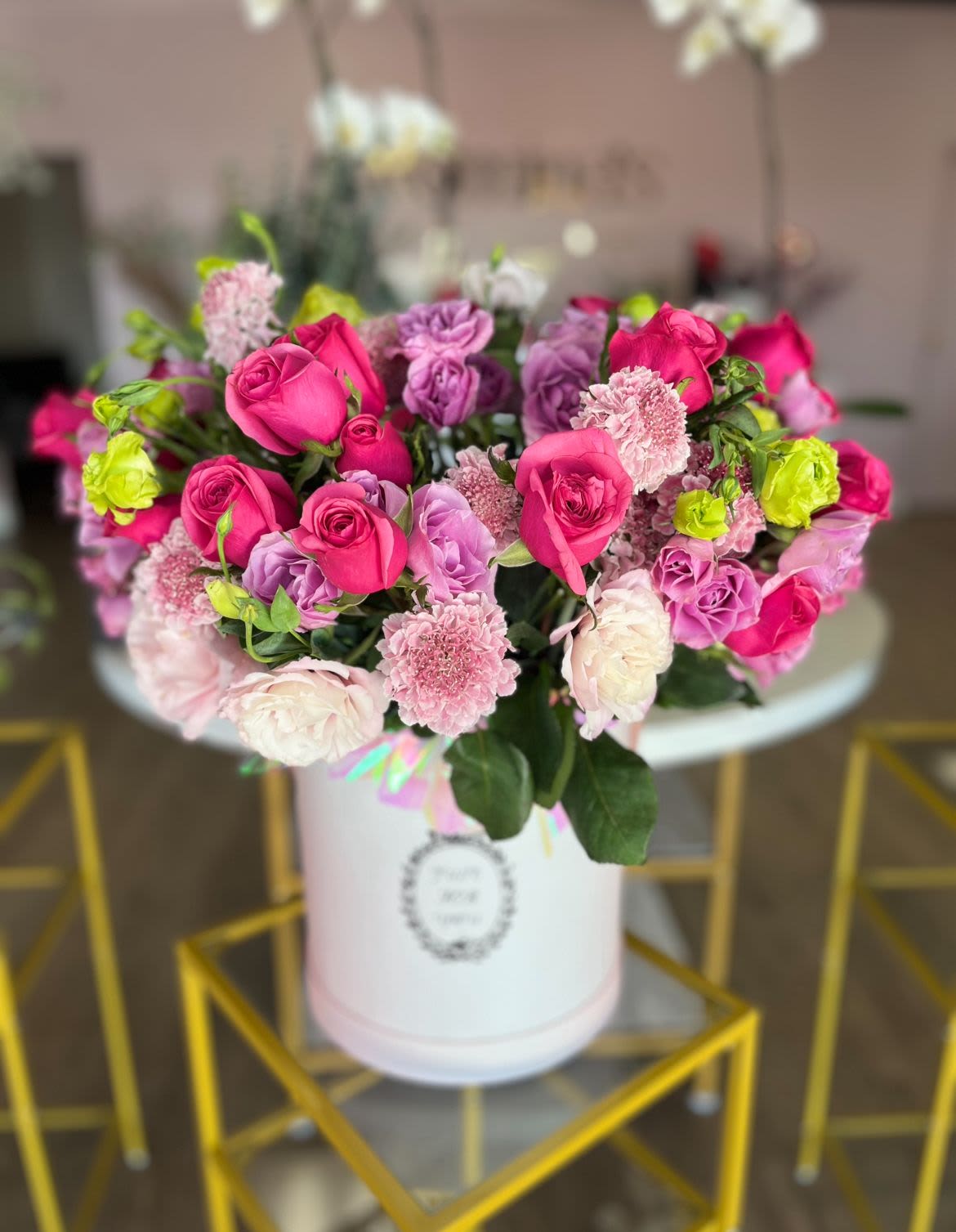 Esther - A vibrant and elegant arrangement that combines the intensity of fuchsia roses with the softness of lilac lisianthus and carefully selected seasonal flowers. This blend of colors and textures creates a harmonious and vibrant composition, perfect for expressing joy and sophistication on any special occasion.  Un arreglo vibrante y elegante que combina la intensidad de las rosas fucsias con la suavidad de los lisianthus lilas y flores de estación cuidadosamente seleccionadas. Esta mezcla de colores y texturas crea una composición armoniosa y llena de vida, perfecta para expresar alegría y sofisticación en cualquier ocasión especial.