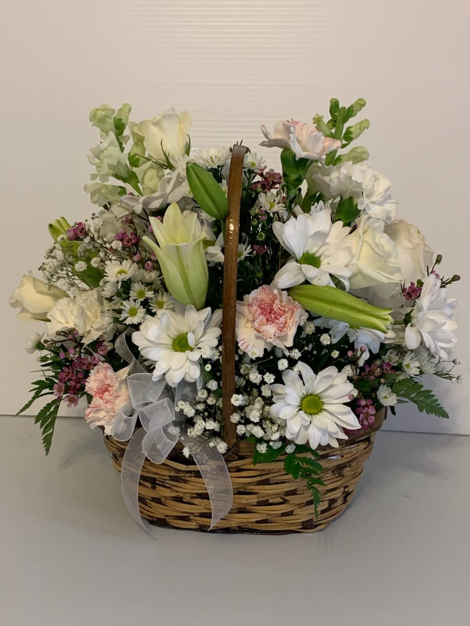 Sweet Angel Basket  - Arrangement includes snapdragons, roses, lilies, carnations, lilies, daisies, filler and assorted greenery in a wicker basket