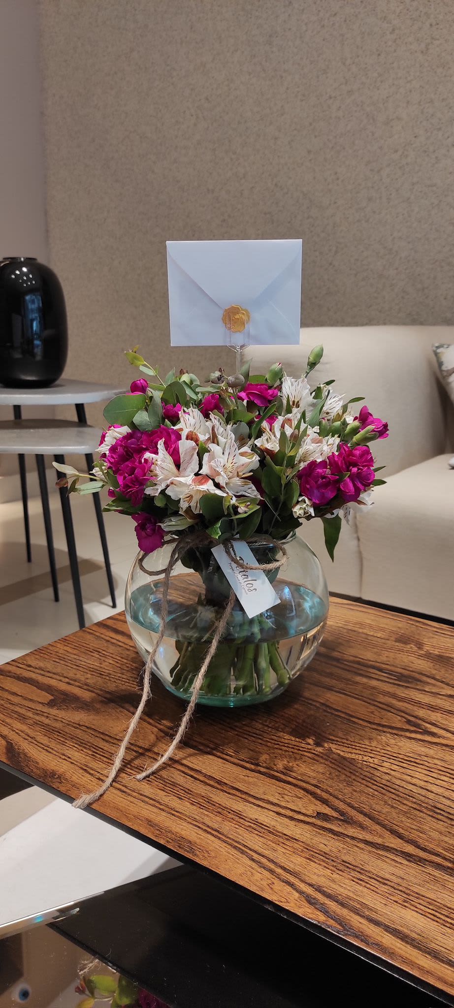 Eva - A simple and elegant floral arrangement presented in a round, fishbowl-style base, offering a panoramic, fresh view from every angle. Ideal for decorating spaces with a natural and minimalist touch, this arrangement combines carefully selected flowers to achieve a harmonious and luminous balance.  Arreglo floral sencillo y elegante presentado en una base redonda estilo pecera, que ofrece una vista panorámica y fresca desde todos los ángulos. Ideal para decorar espacios con un toque natural y minimalista, este arreglo combina flores seleccionadas cuidadosamente para lograr un balance armonioso y luminoso.
