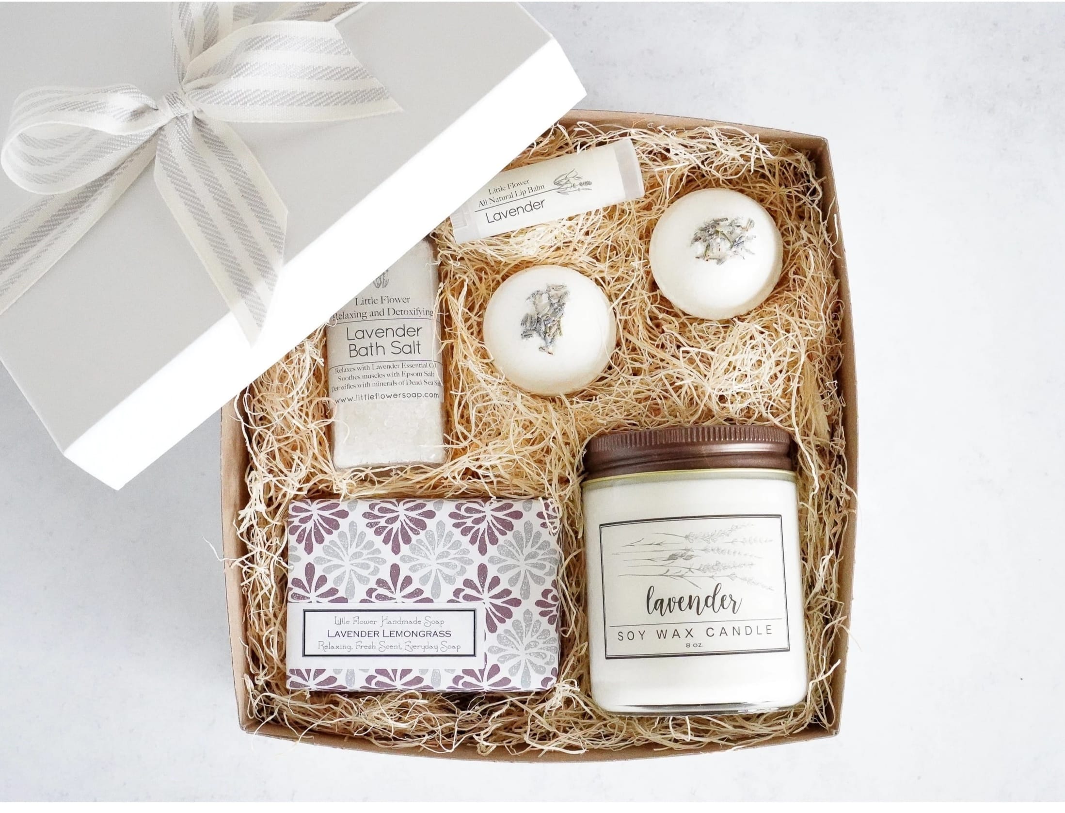 Little Flower Soap Co - Luxury Lavender Spa Gift Box  - Ready to Gift Luxury Spa Box Measures 8 x 8 and comes in a white gift box with an organic cotton grey and white stripe bow (as pictured).  Perfect for all those last minute customers. Choose from Standard &quot;Lavender&quot; candle label or &quot;Love You Mom&quot; candle label.  INCLUDES: 1 - 6oz BIG soap Lavender Lemongrass 1 - Lavender Lip Balm 1 - 4oz Lavender Bath Salt with Dead Sea Salt and Epsom 2 - 2oz Lavender Bath Bombs topped with rose petals 1 - 8oz Lavender Candle - select either general “Lavender” or “Love You Mom” label for candle 1 - White gift box with Grey and Ivory Organic Cotton striped Ribbon Made in United States