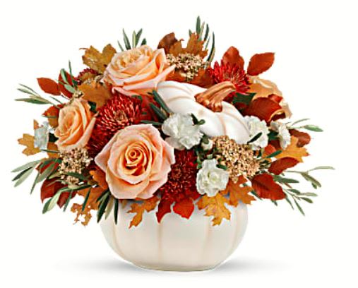 Harvest Charm - Elegant crème roses blend with the heartwarming hues of autumn in this charming bouquet, artfully arranged in a white lidded pumpkin bowl, a versatile fall decor favorite! This charming arrangement features crème roses, white miniature carnations, burgundy cushion spray chrysanthemums, yellow cottage yarrow, olive, and brown copper beech. Delivered in an Enchanted Harvest Pumpkin. Orientation: All-Around