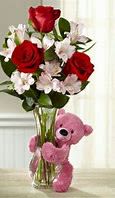Huggable Love (Brown or White) Bear &amp; Rose Bouquet - This Huggable Love Bear &amp; Rose Bouquet is the perfect way to express love and affection this Valentine’s Day! A charming plush teddy bear, available in varying colors, wraps its soft arms around a gorgeous glass vase filled with lush red roses and delicate white alstroemeria, creating a romantic and heartwarming display.  Whether you're celebrating a new romance, a long-lasting love, or simply want to make someone smile, this delightful combination of classic blooms and a cuddly plush companion is the ultimate gift of love.  Why It’s Perfect for Valentine’s Day:  Elegant Red Roses: The timeless symbol of love and passion.  Soft White Alstroemeria: A touch of elegance and purity.  Adorable Plush Teddy Bear (Colors Vary): A lovable keepsake that adds warmth and charm.  Beautiful Glass Vase: A stylish, ready-to-gift floral presentation.  Perfect Gift Pairing:  Add Chocolates for an extra sweet surprise.  Pair with a Valentine’s Balloon for an even bigger statement.  A Memorable Keepsake that will be cherished long after the flowers fade. Order the Huggable Love Bear &amp; Rose Bouquet today and make this Valentine’s Day truly unforgettable! ️