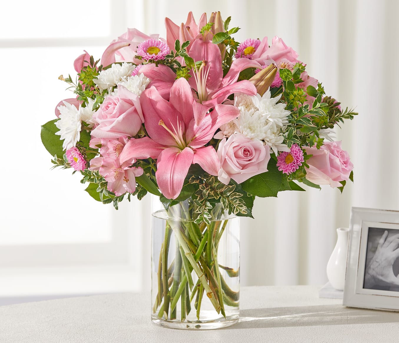 Healing Hug Bouquet - The Healing Hug Bouquet is a warm embrace in floral form, designed to uplift and comfort. This arrangement combines pink roses, alstroemeria, Matsumoto asters, and lilies with soft white cushion pompons, creating a soothing balance of color and texture.  A heartfelt choice for sending encouragement, expressing sympathy, or celebrating life’s tender moments.  Approximately 17&quot;h x 16&quot;w