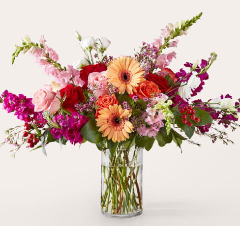 Renaissance Bouquet Renaissance Bouquet - Bold, bright, and bursting with contrast. The Renaissance Bouquet blends peach gerbera daisies, vibrant roses, lisianthus, snapdragons, and stock in a garden-style display, arranged in a tall glass cylinder. Perfect for birthdays, milestones, or anyone who needs a burst of color and confidence. Approximately 19"H x 24"W.