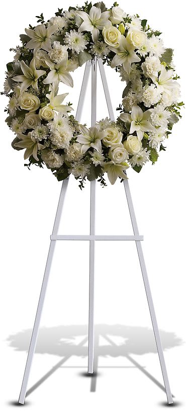  Heavenly White Wreath - Fragrant and ethereal white blossoms set among a ring of soothing greens form a classic wreath certain to evoke the pure heart and gentle spirit of a loved one and offer consolation during a funeral or wake. Delivered on an easel, a standing wreath comprising fresh flowers such as white roses, lilies, and other fresh seasonal white blooms. Approximately 27&quot; W x 27&quot; H.